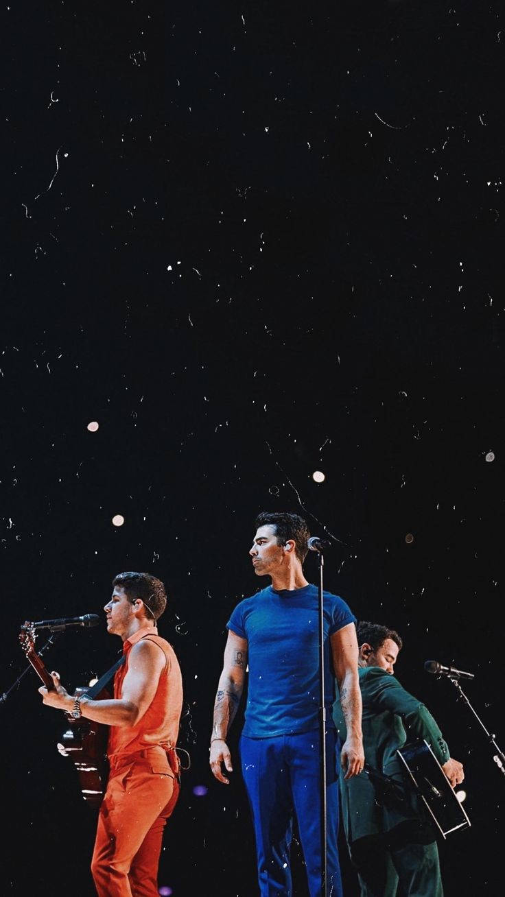 Jonas Brothers Singing On Stage Background
