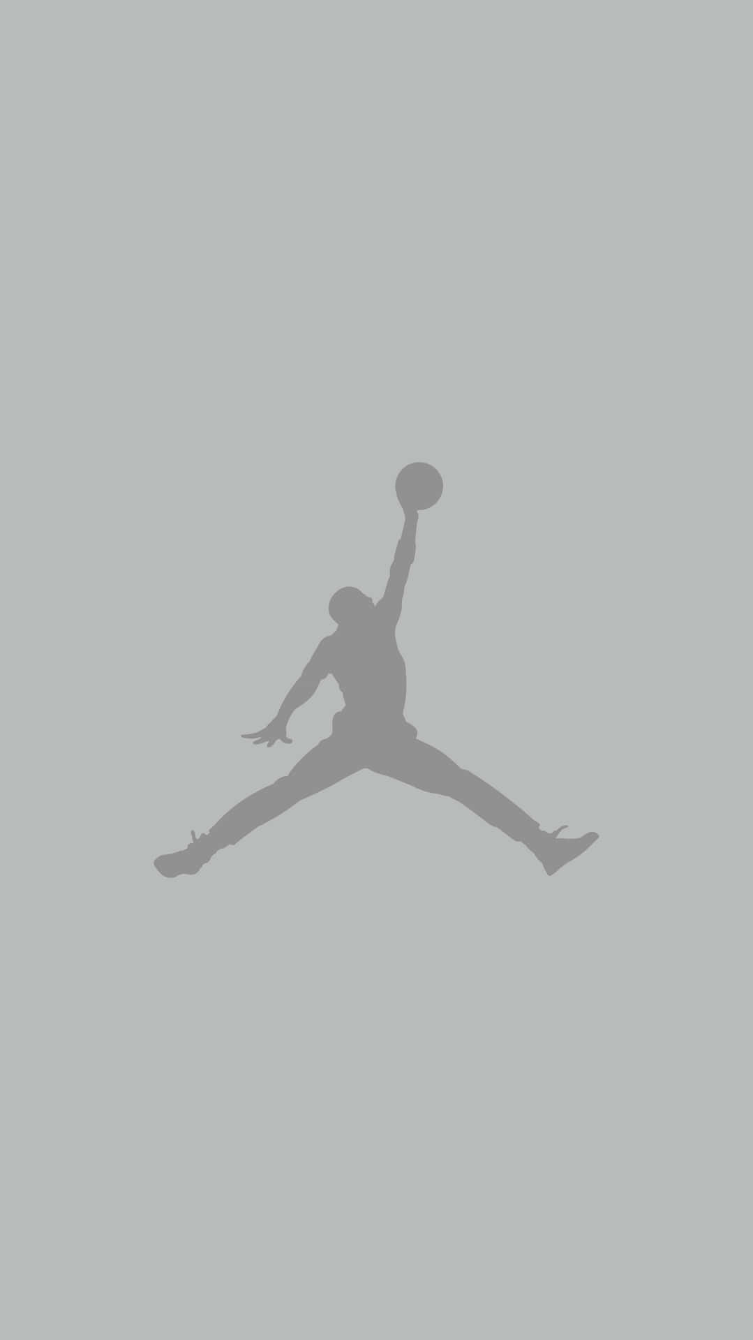 En silhuet af en basketballspiller der hopper i luften Wallpaper
