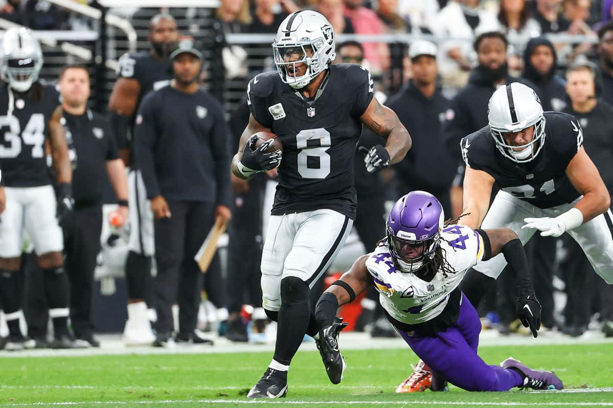 Josh Jacobs Evading Tackle During Game Wallpaper