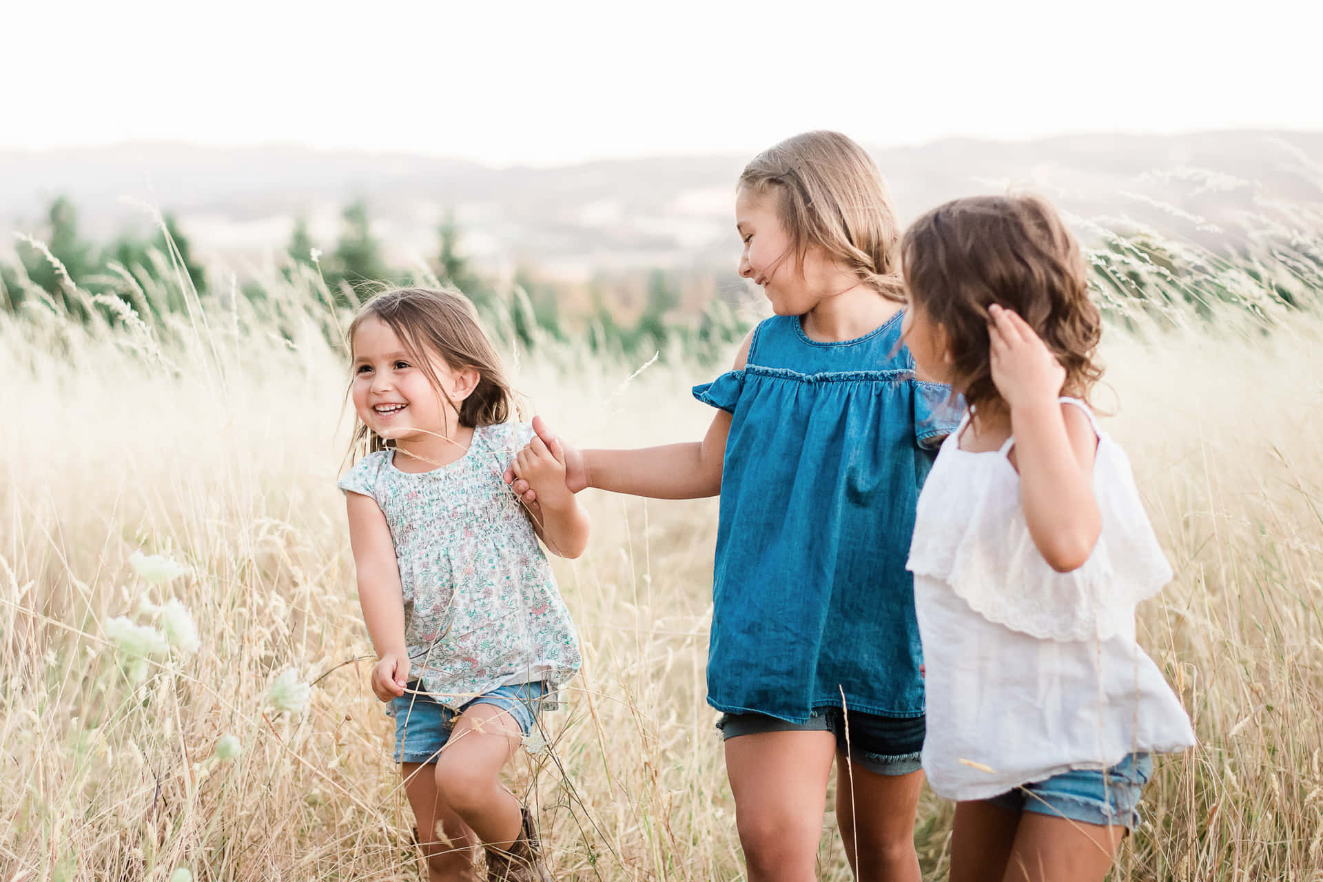 Joyful Sisters Celebrating Togetherness Outdoors Wallpaper