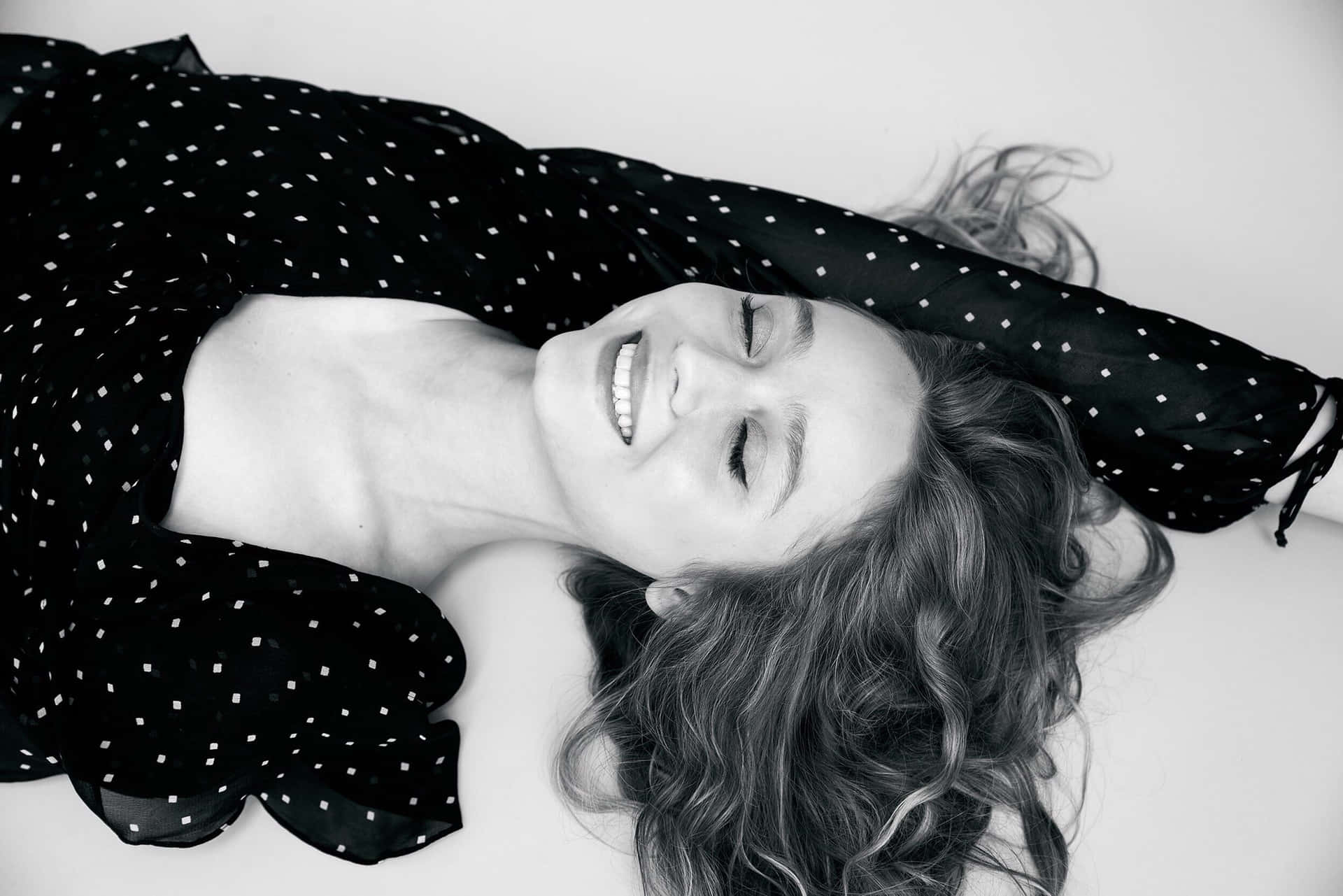 Joyful Woman Lying Down Blackand White Photo Wallpaper