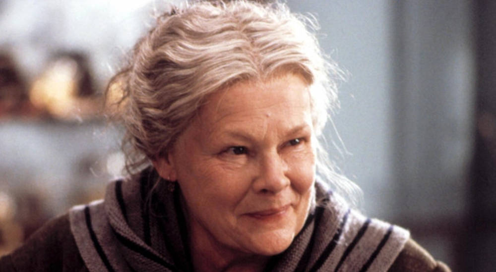 Legendary Actress Judy Dench with a vibrant smile Wallpaper