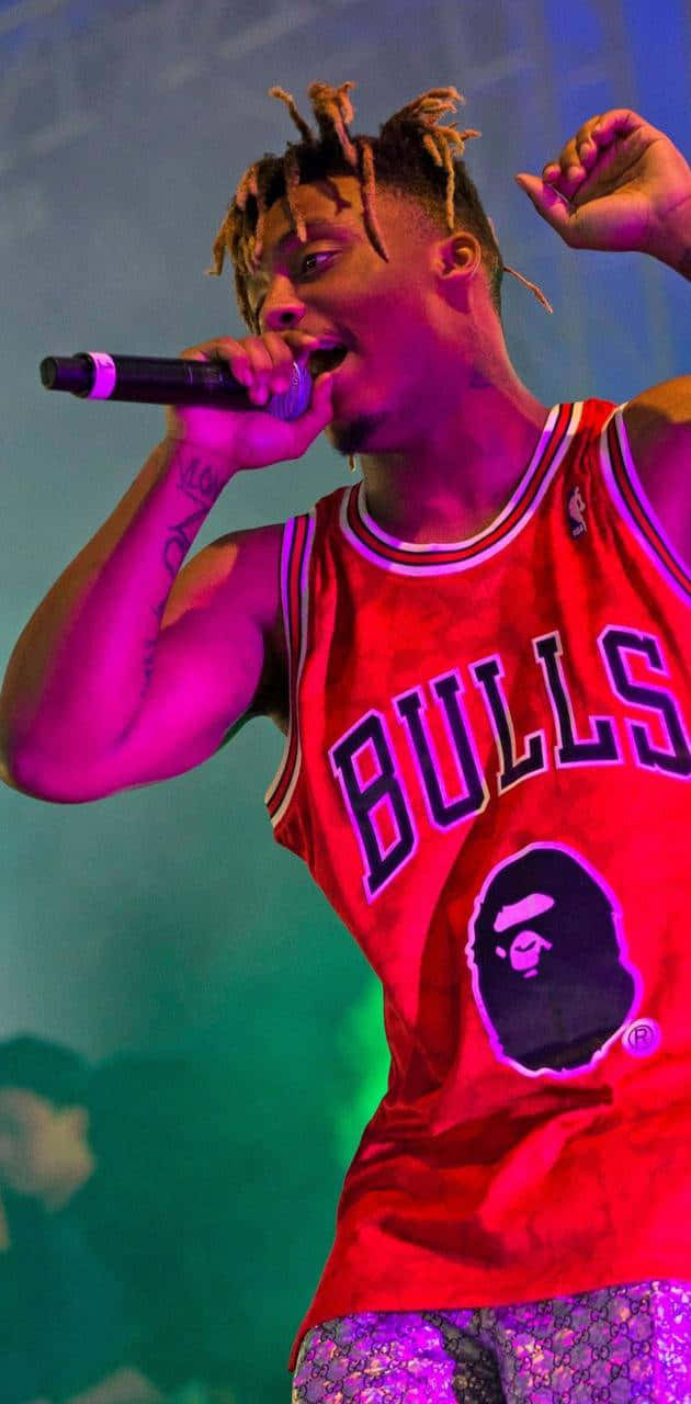 Unhombre Con Una Camiseta De Los Chicago Bulls Cantando En Un Micrófono Fondo de pantalla