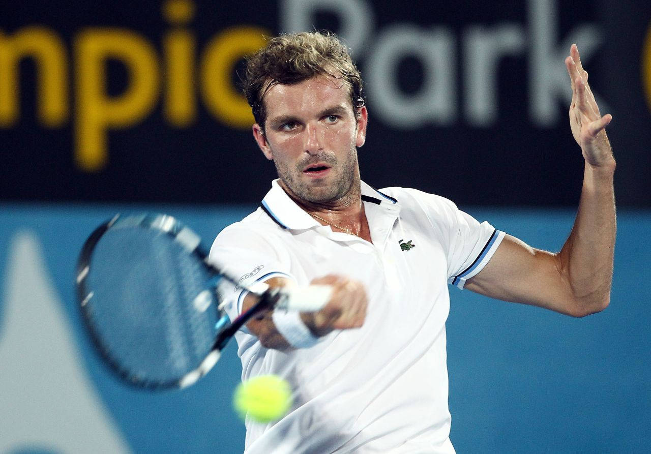 Julien Benneteau in action, expertly launching the tennis ball with his racket Wallpaper