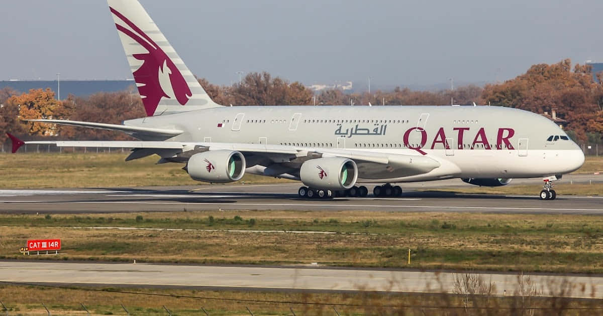 Et Qatar Airways fly letter op fra en lufthavn. Wallpaper