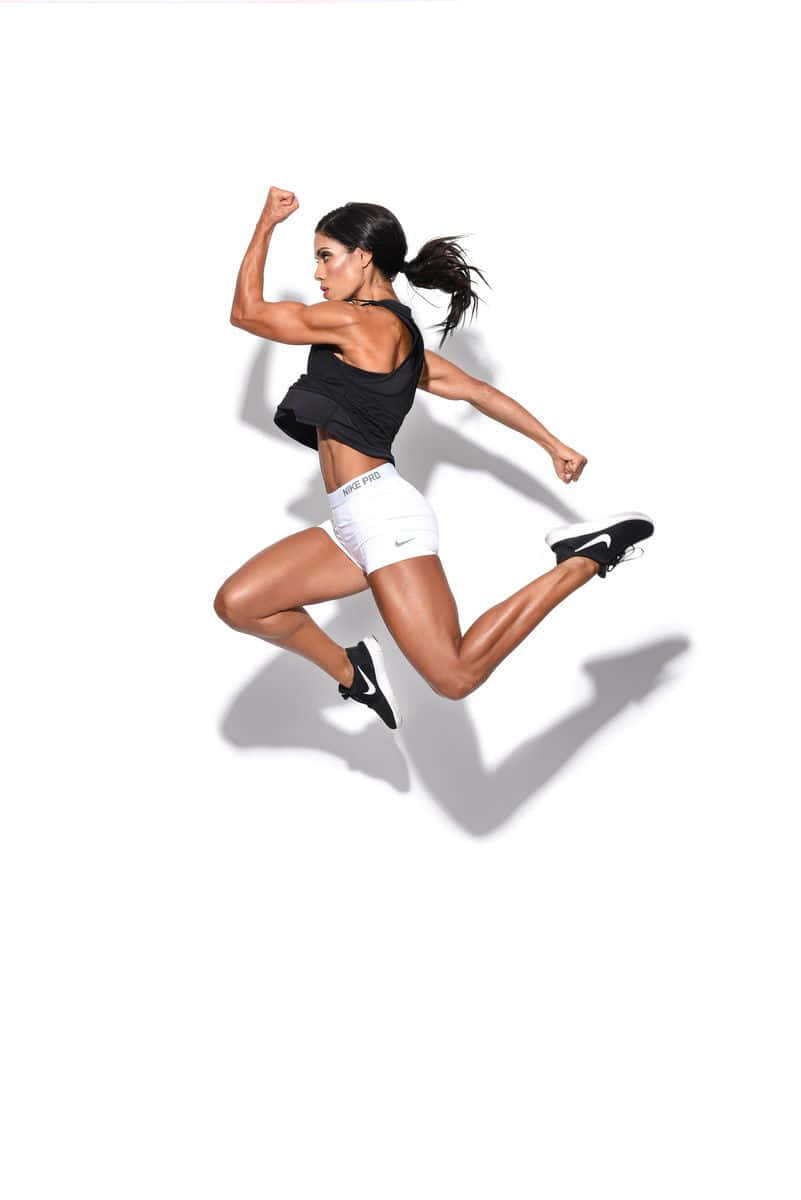 A Woman In White Shorts And Black Shoes Jumping In The Air