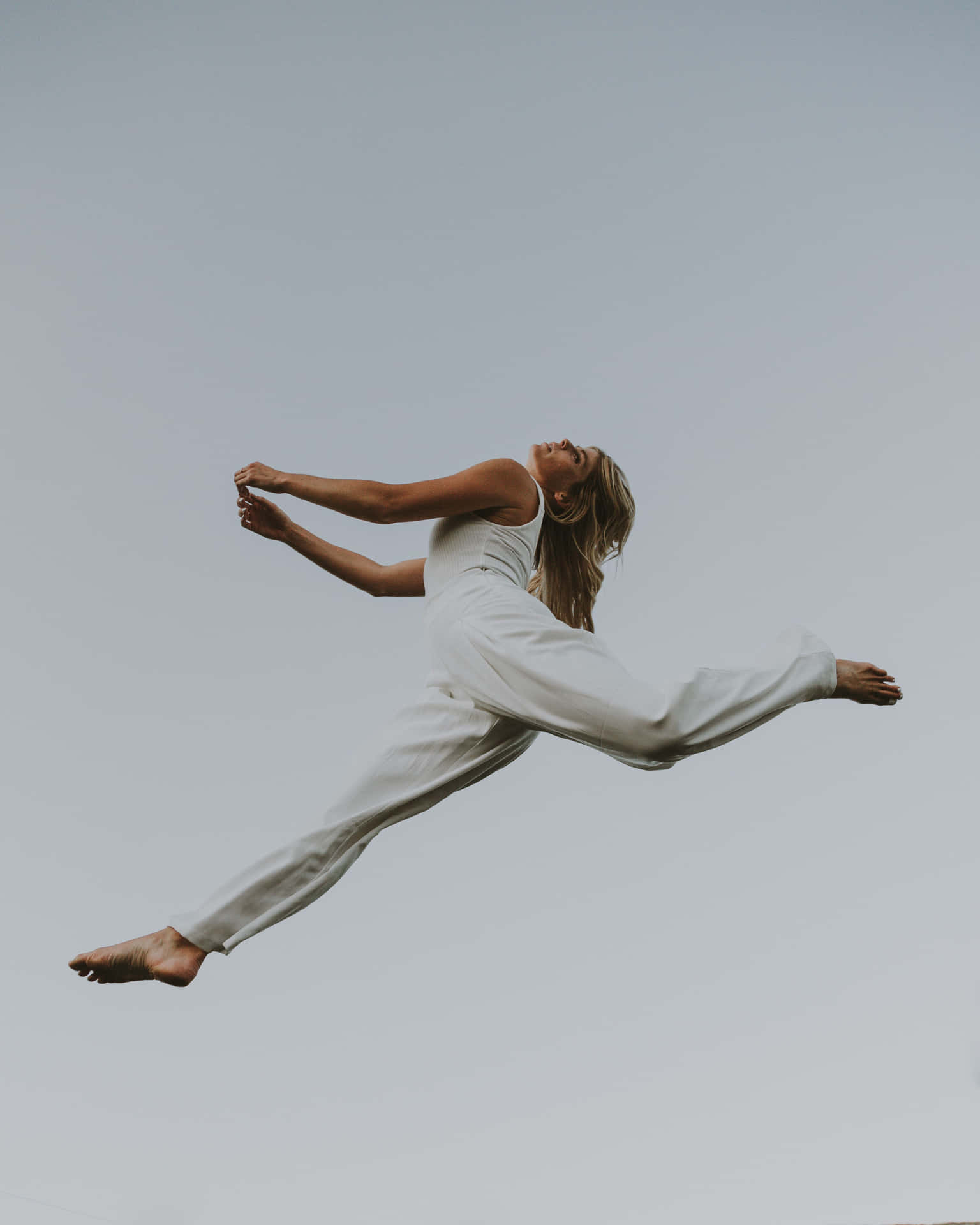 A Woman In White Jumps In The Air