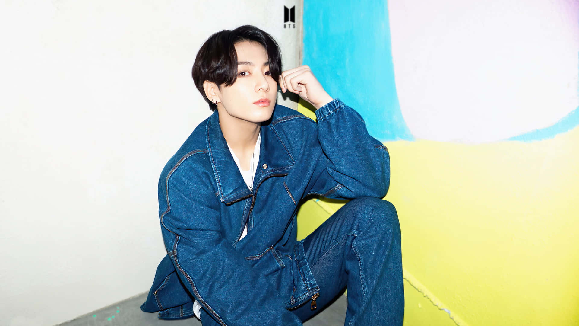 Jungkook striking a pose in a stylish outfit