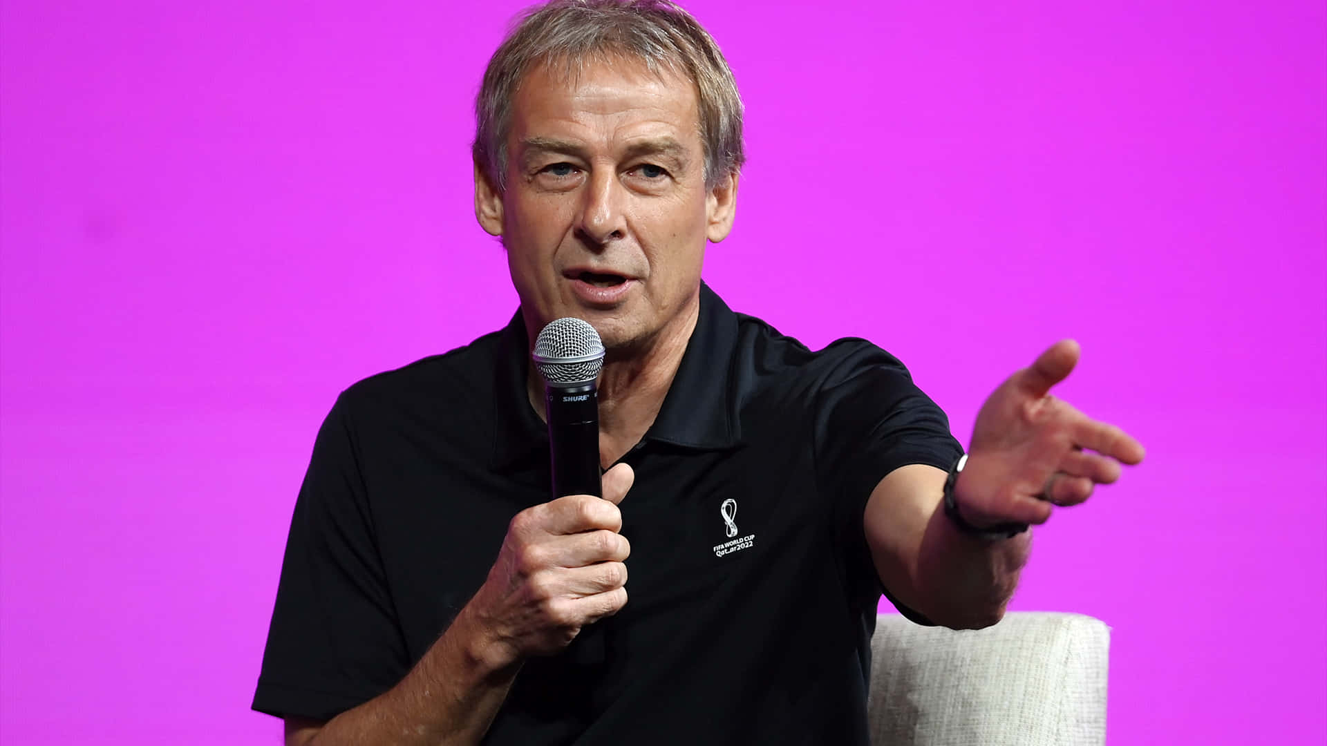 Jurgen Klinsmann Speaking On Microphone Wallpaper