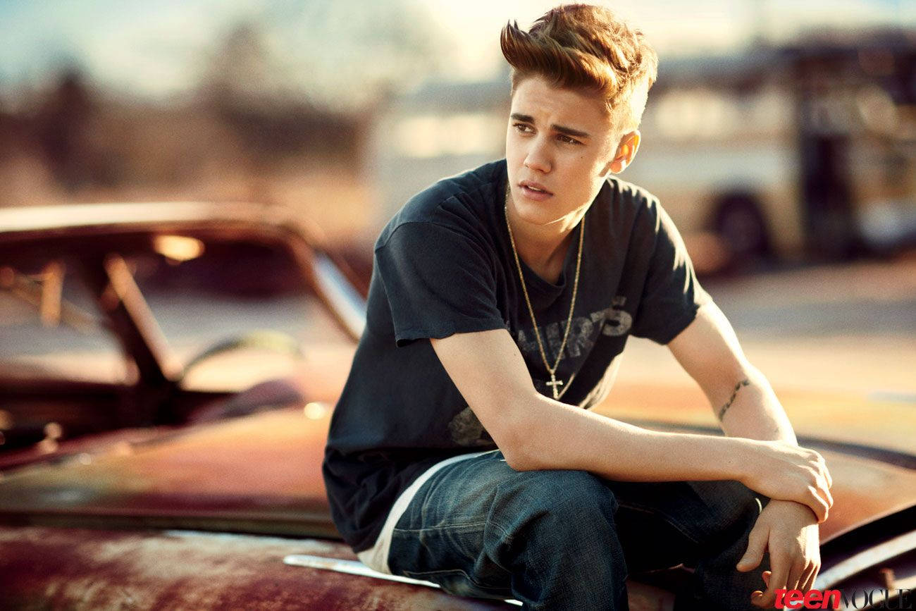 Justin Bieber poses with a vintage car. Wallpaper