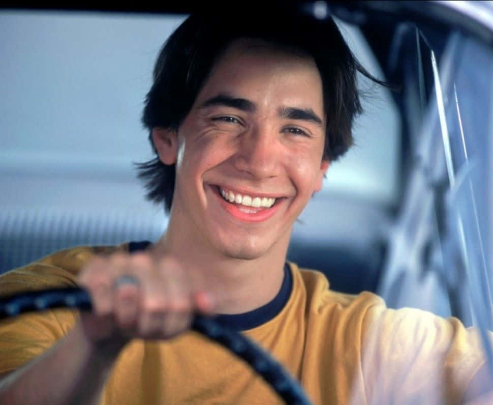 Justin Long striking a casual pose on an urban streetscape Wallpaper