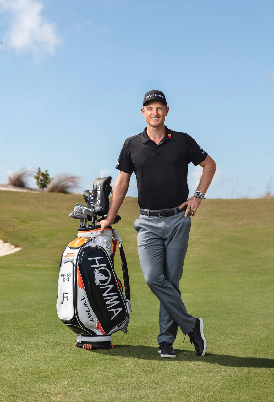 Justin Rose Leaning On A Golfing Bag Wallpaper