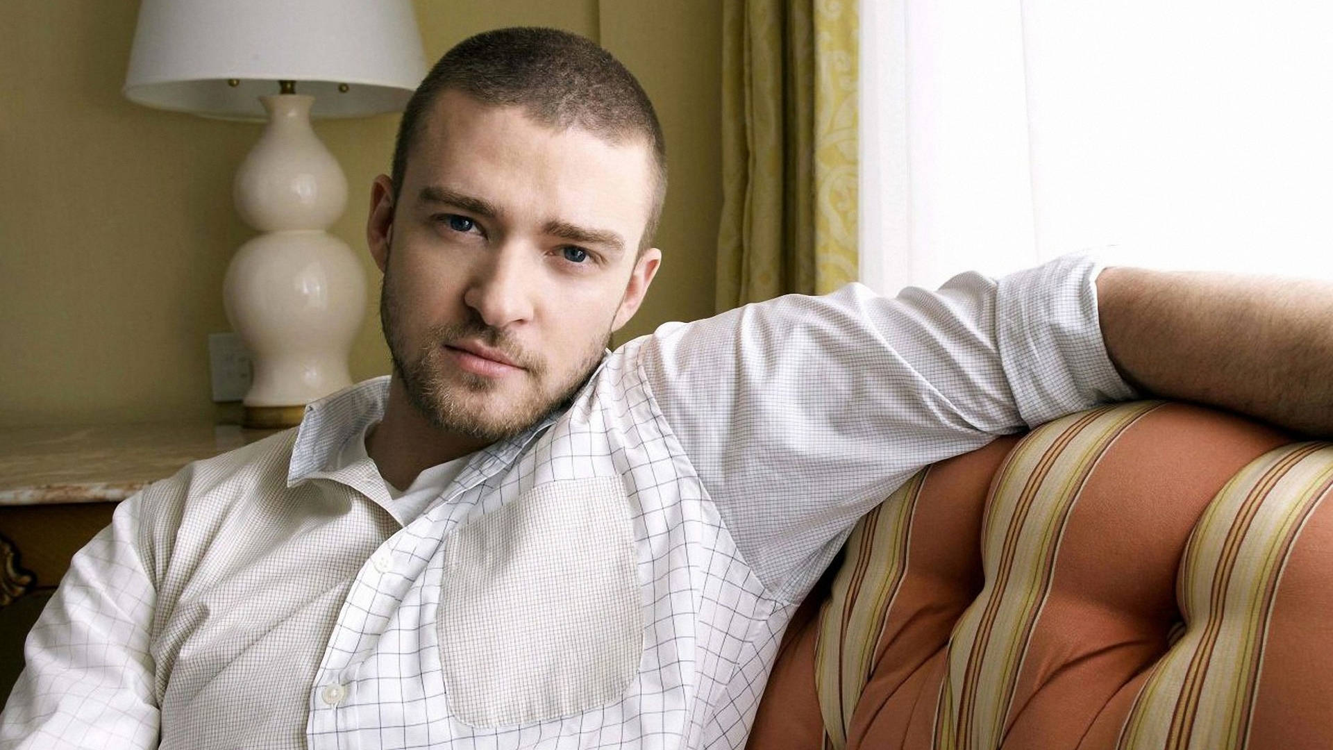 Justin Timberlake Posing På Sofa Wallpaper