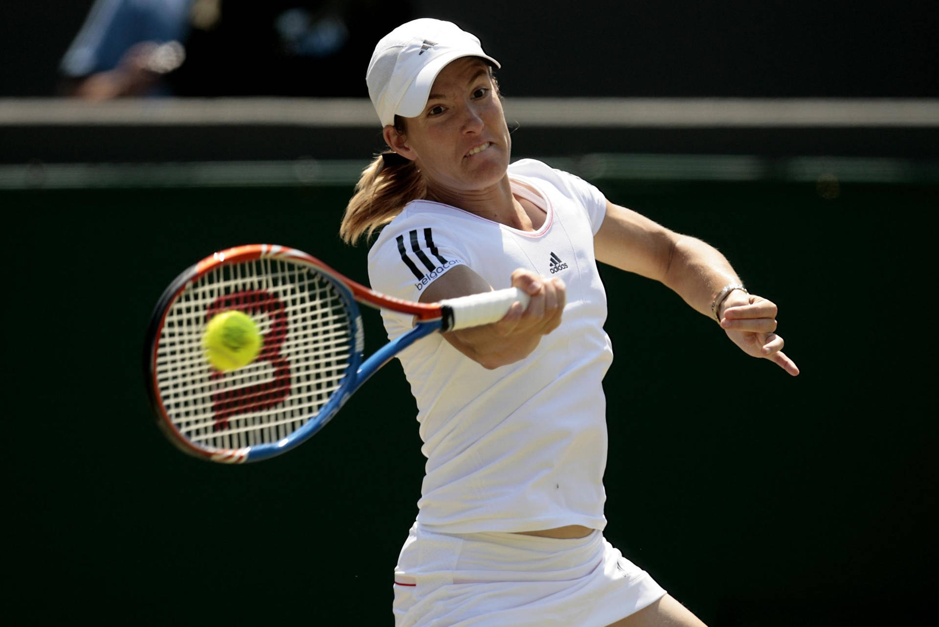 Justine Henin displaying her powerful backhand during a match Wallpaper