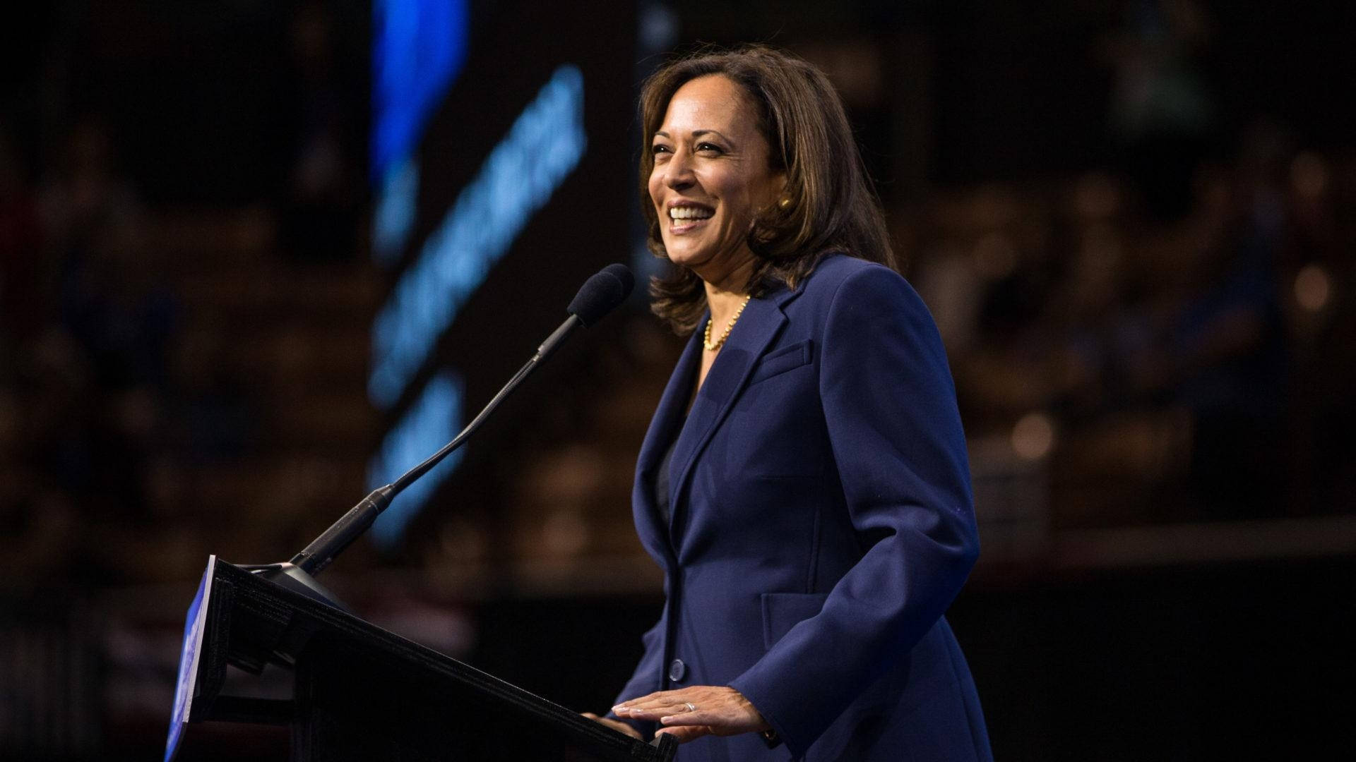 Kamalaharris Leende På Scenen. (this Would Be A Suitable Translation For A Computer Or Mobile Wallpaper Featuring Kamala Harris Smiling Onstage.) Wallpaper