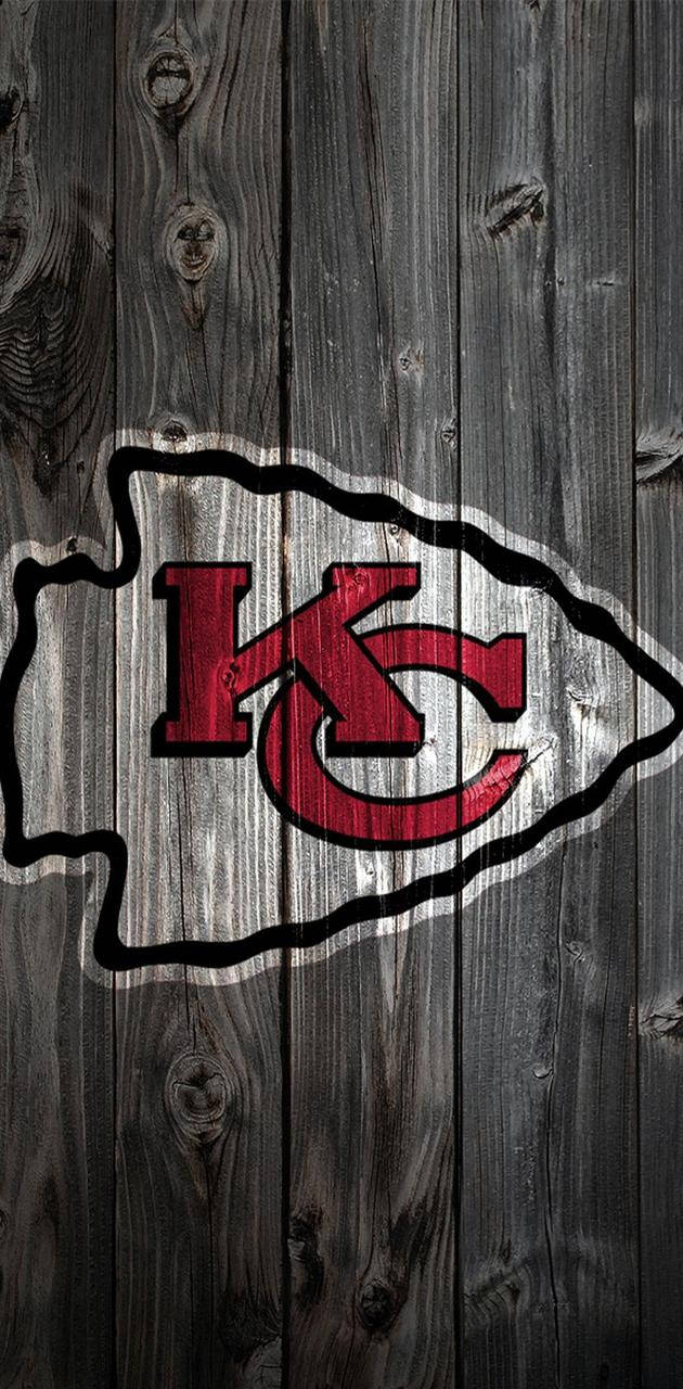 Logo af Kansas City Chiefs på mørkt træ tapet Wallpaper