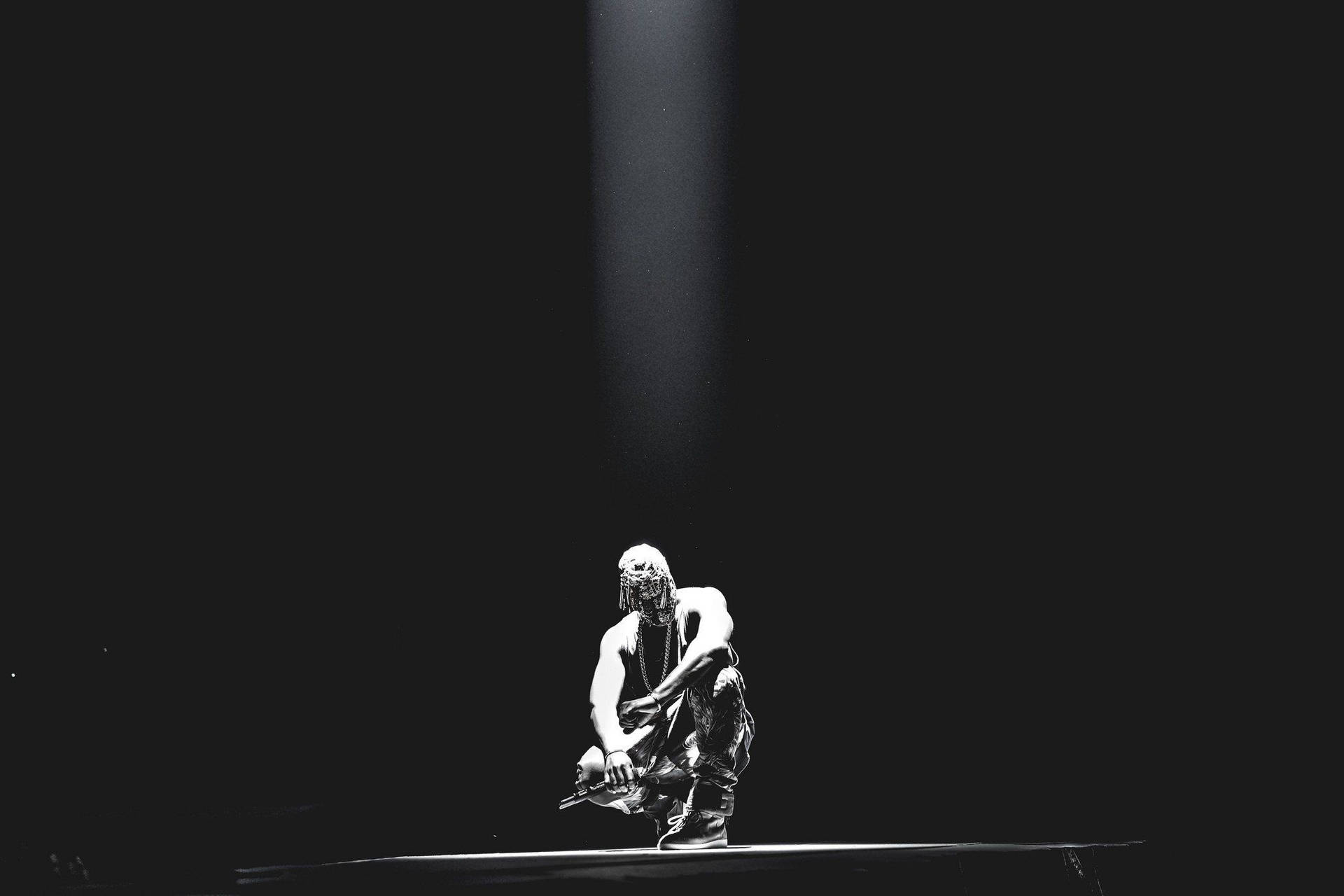 Kanye West Kneeling Under Light Background