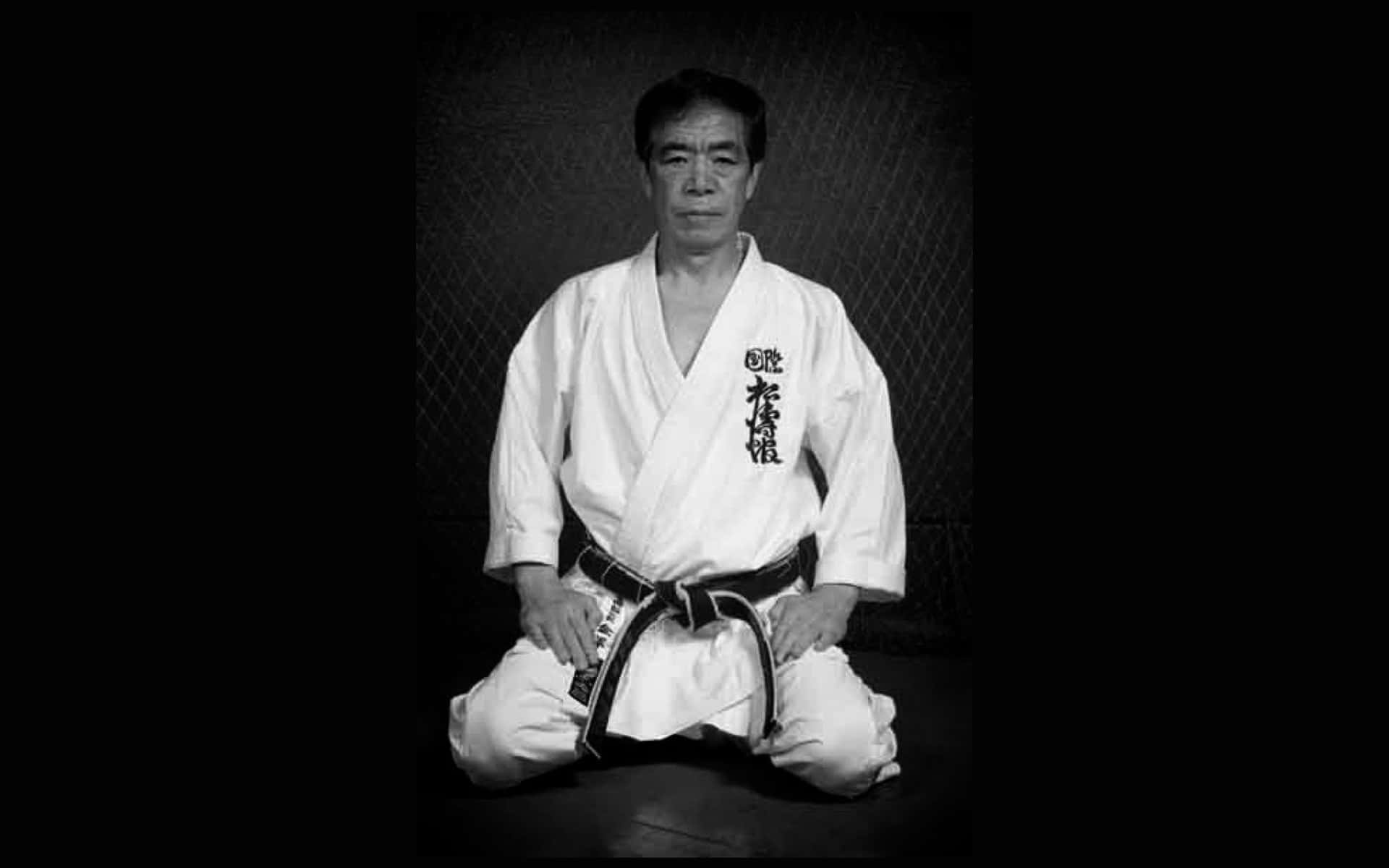 A Man In A Karate Uniform Sitting On The Ground