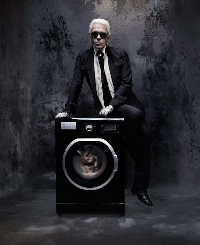 A Man In A Suit Sitting On A Washing Machine Wallpaper