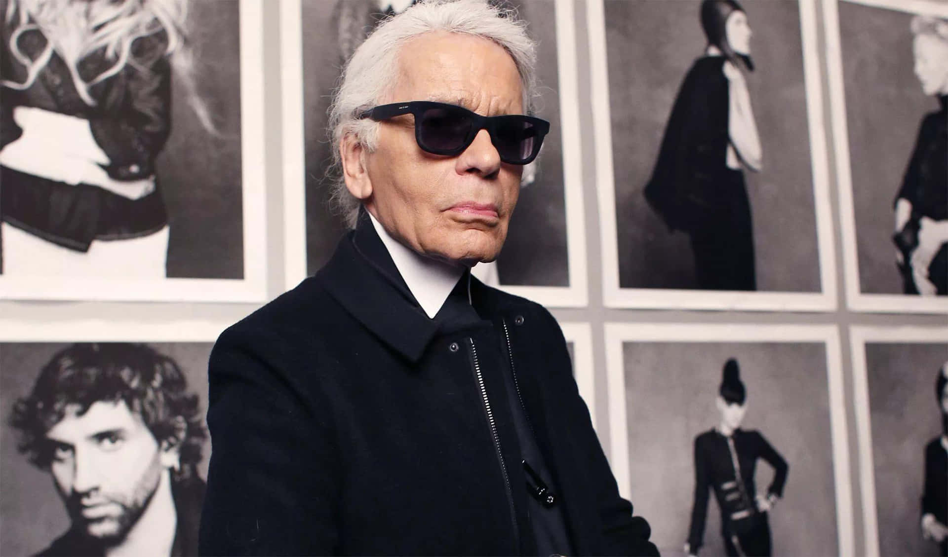 Karl Lagerfeld - A Man In Sunglasses Standing In Front Of A Wall Of Photos Wallpaper