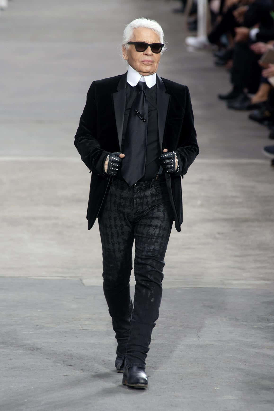 Karl Lagerfeld i sine ikoniske mørke briller og fingerløse handsker dekorerer denne stilfulde tapet. Wallpaper