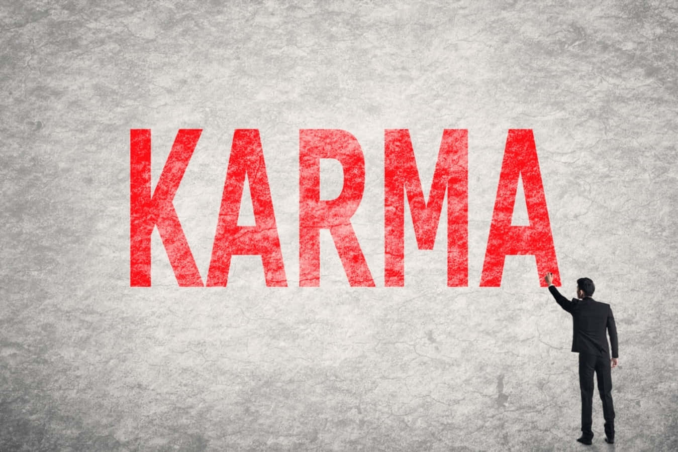 A Man In A Suit Is Pointing To The Word Karma