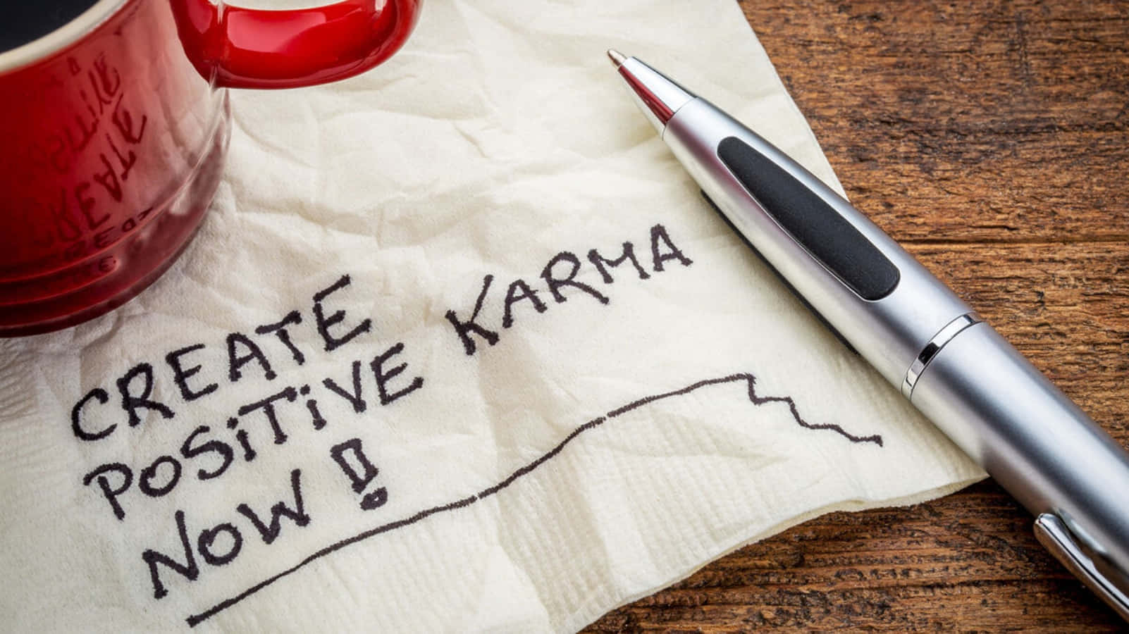 A Napkin With The Words Create Positive Karma Now