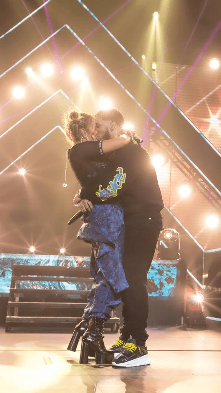 Karol G Kissing On Stage Background