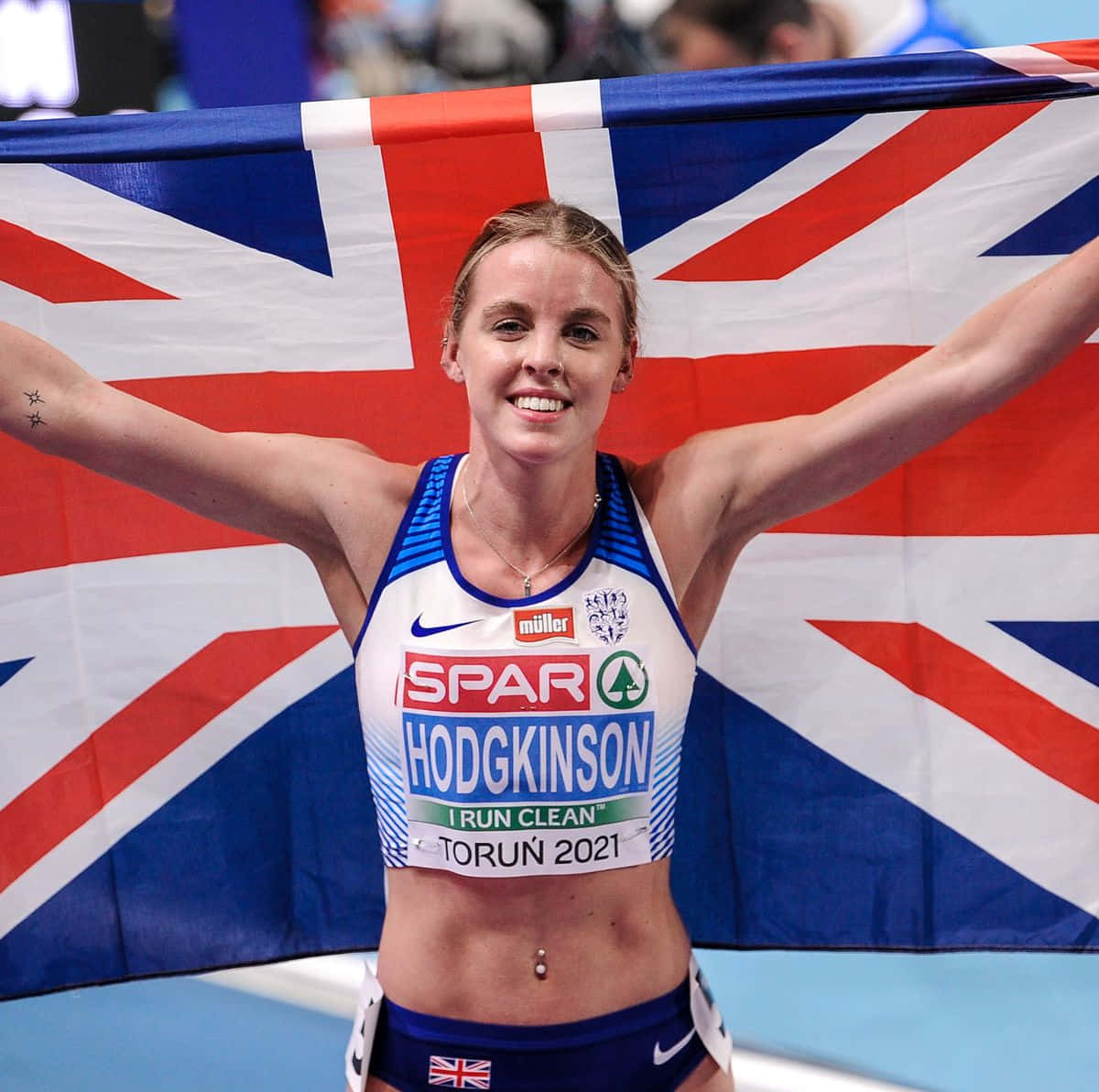 A Female Athlete Holding Up An British Flag Wallpaper