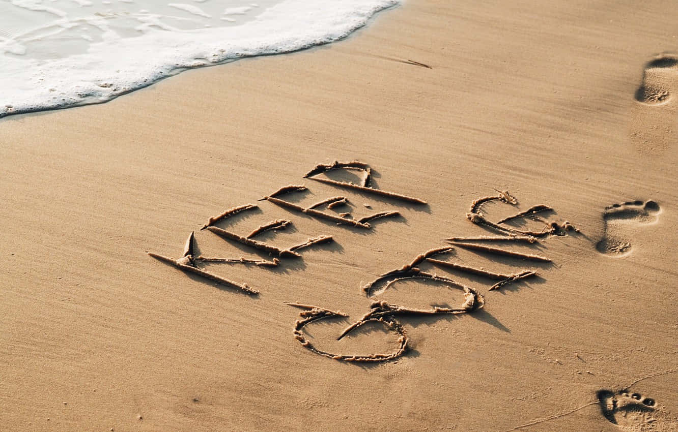 A Beach With A Word Written In The Sand Wallpaper