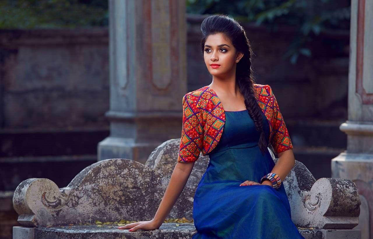 Keerthi Suresh Relaxing on a Stone Bench in High Definition Wallpaper