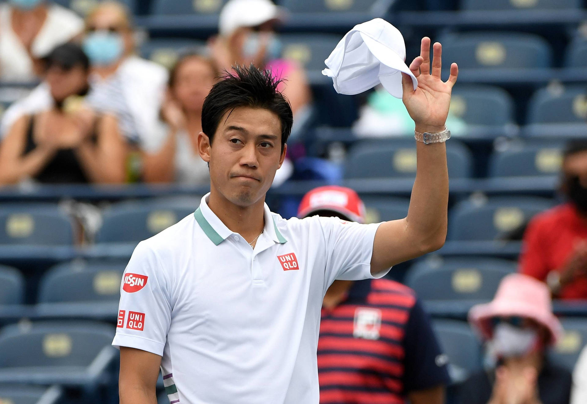 a tennis player is waving his hat to the crowd Wallpaper