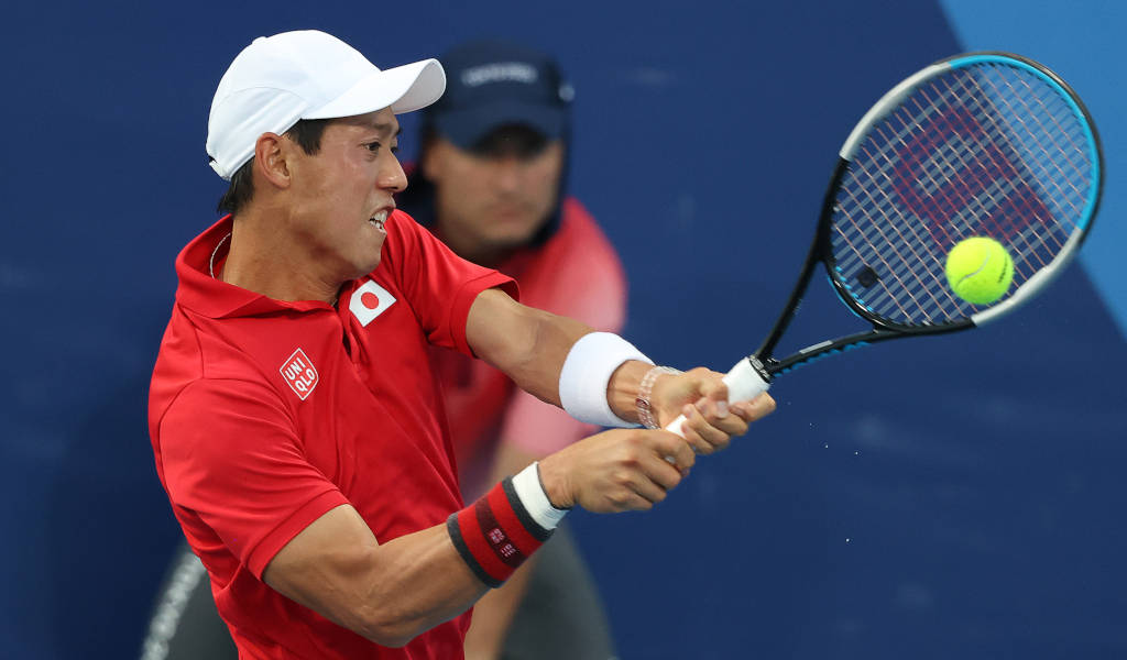 a man in a red shirt is hitting a tennis ball Wallpaper