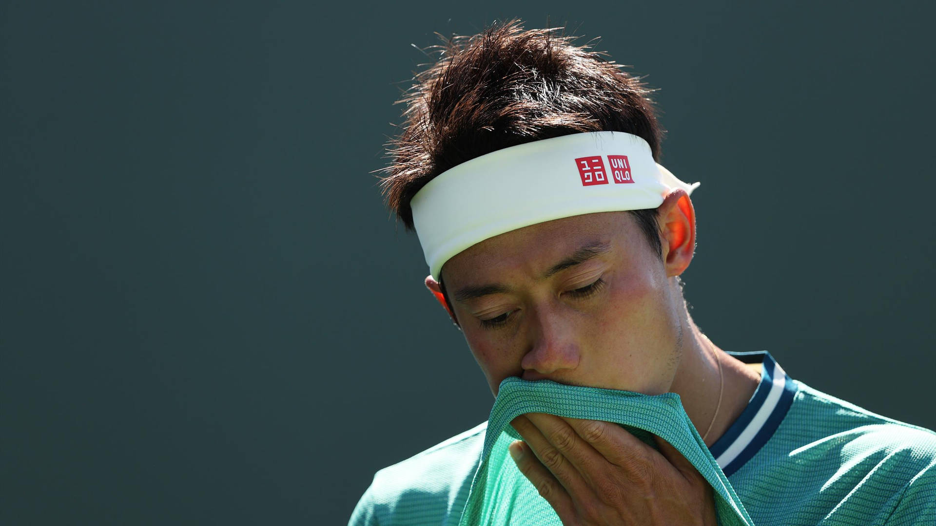 A Tennis Player Is Wiping His Face With A Towel Wallpaper