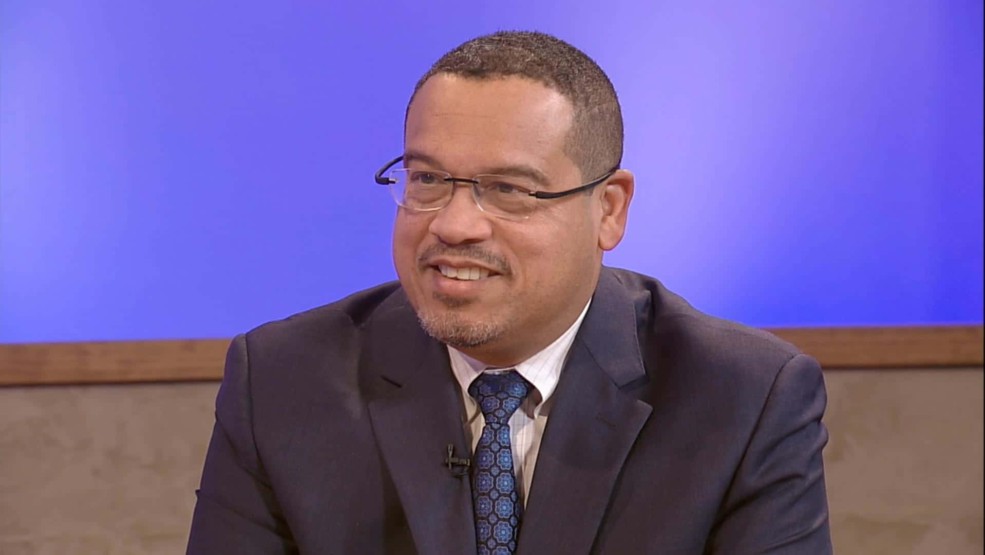Keith Ellison In Blue And Brown Wall Wallpaper