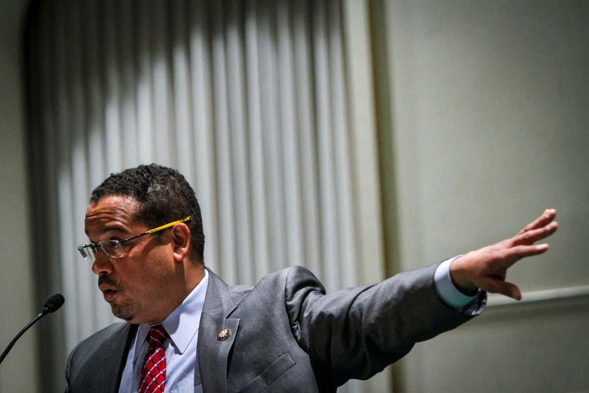 Keith Ellison Reaching To His Side Wallpaper