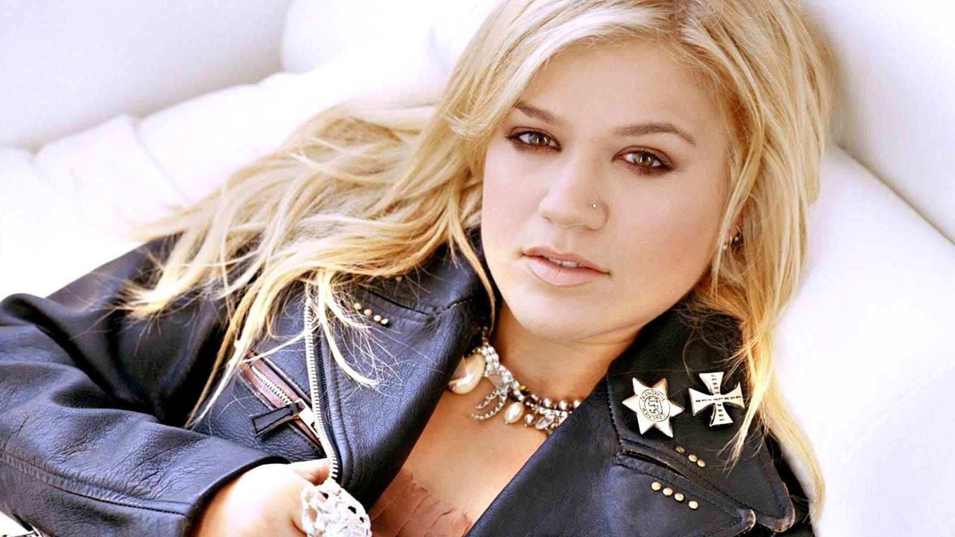 Kelly Clarkson On Bed Lying Background