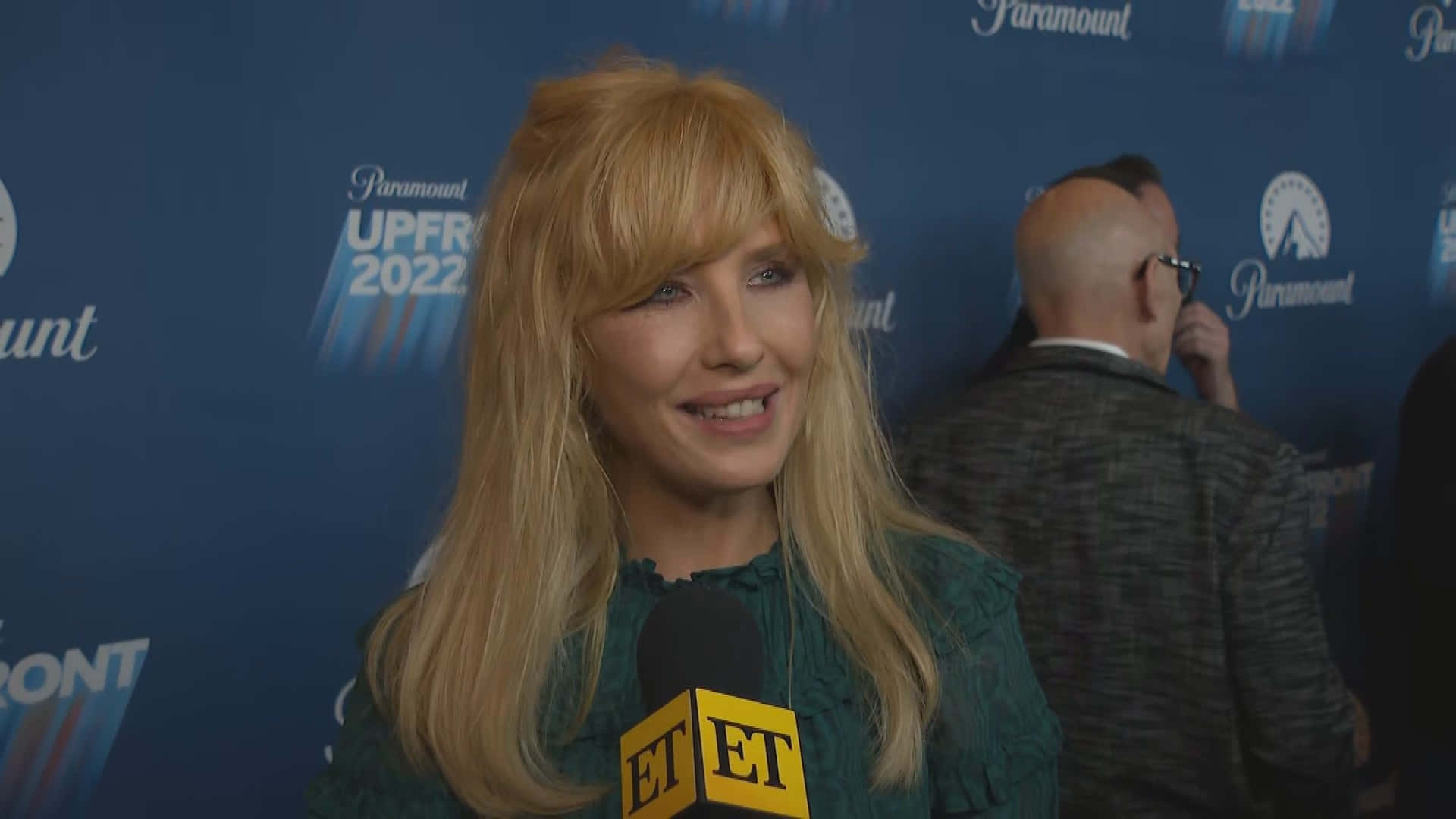 A Blonde Woman Talking To A Reporter On A Red Carpet