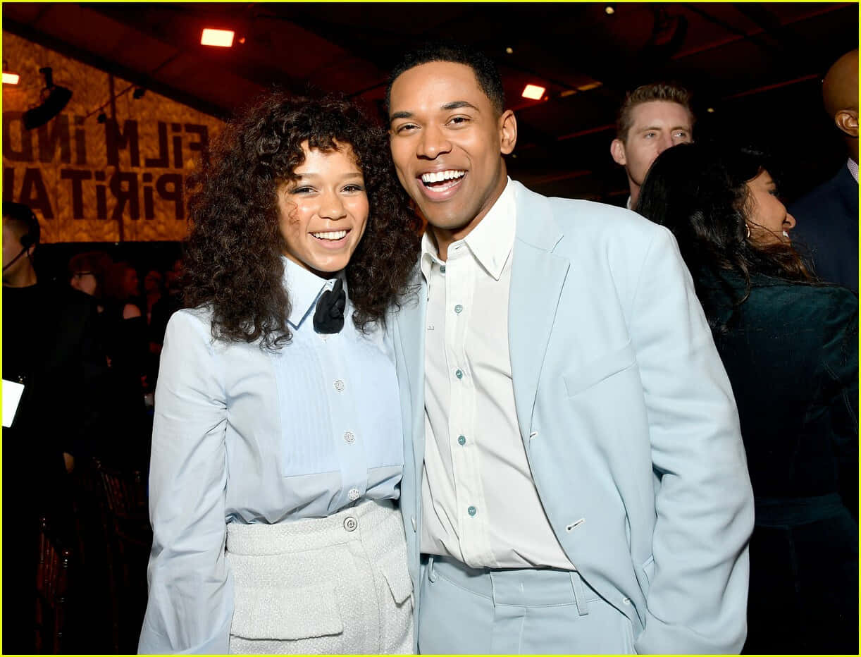 Kelvin Harrison Jr. Glimlachend Met Vrouwelijke Companion Evenement Achtergrond