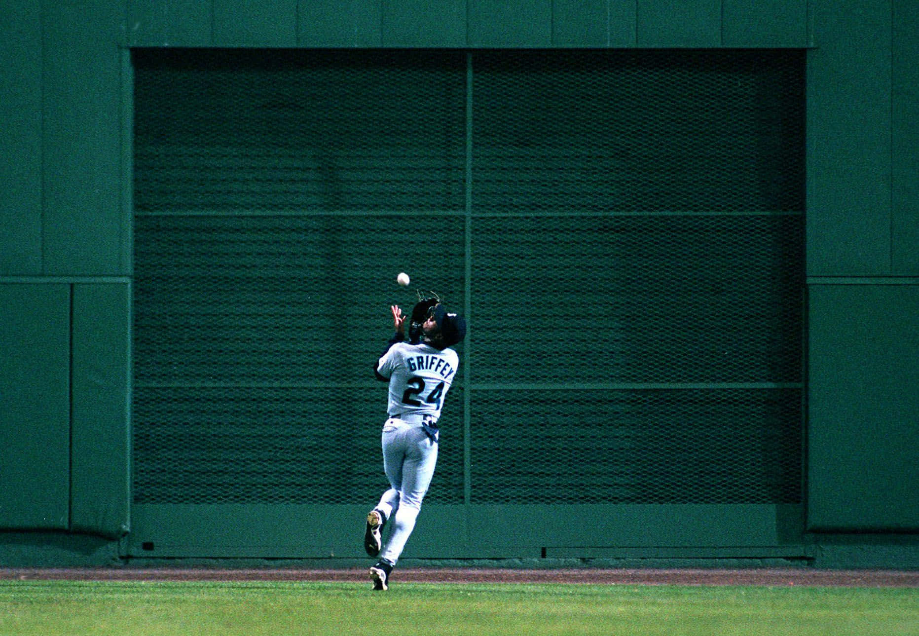 A Baseball Player Catching A Ball Wallpaper