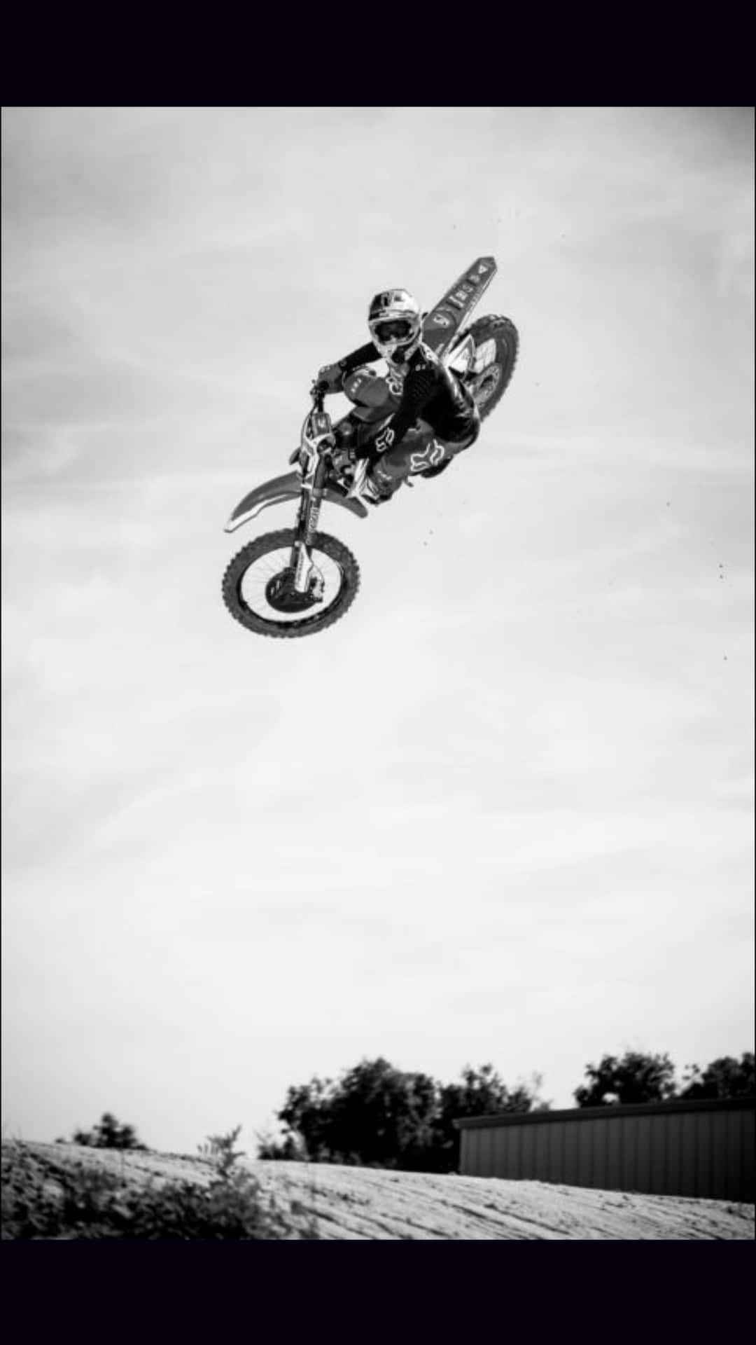 A Person Riding A Dirt Bike In The Air Wallpaper