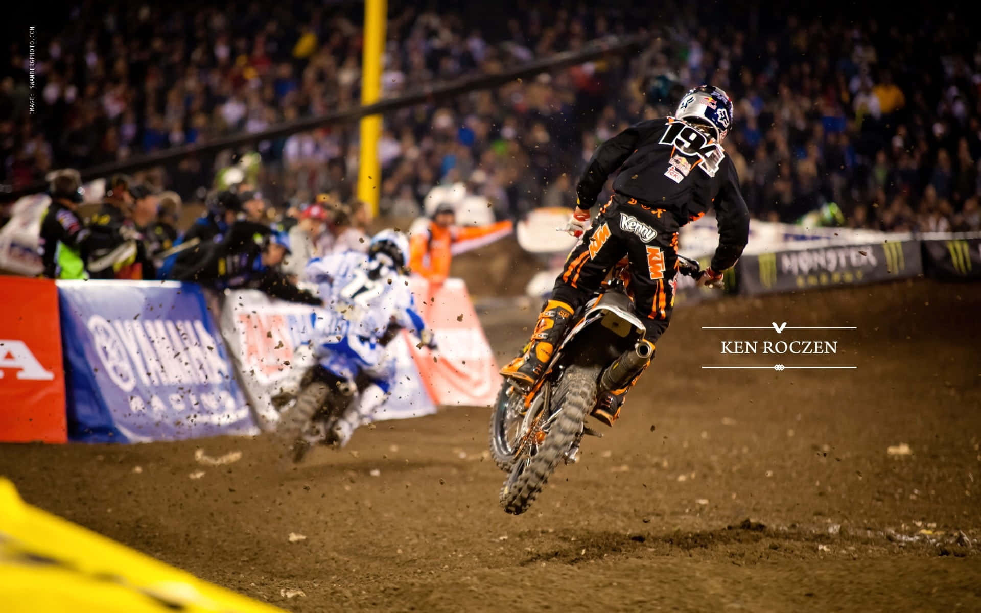 A Dirt Bike Rider Is In The Air During A Race Wallpaper