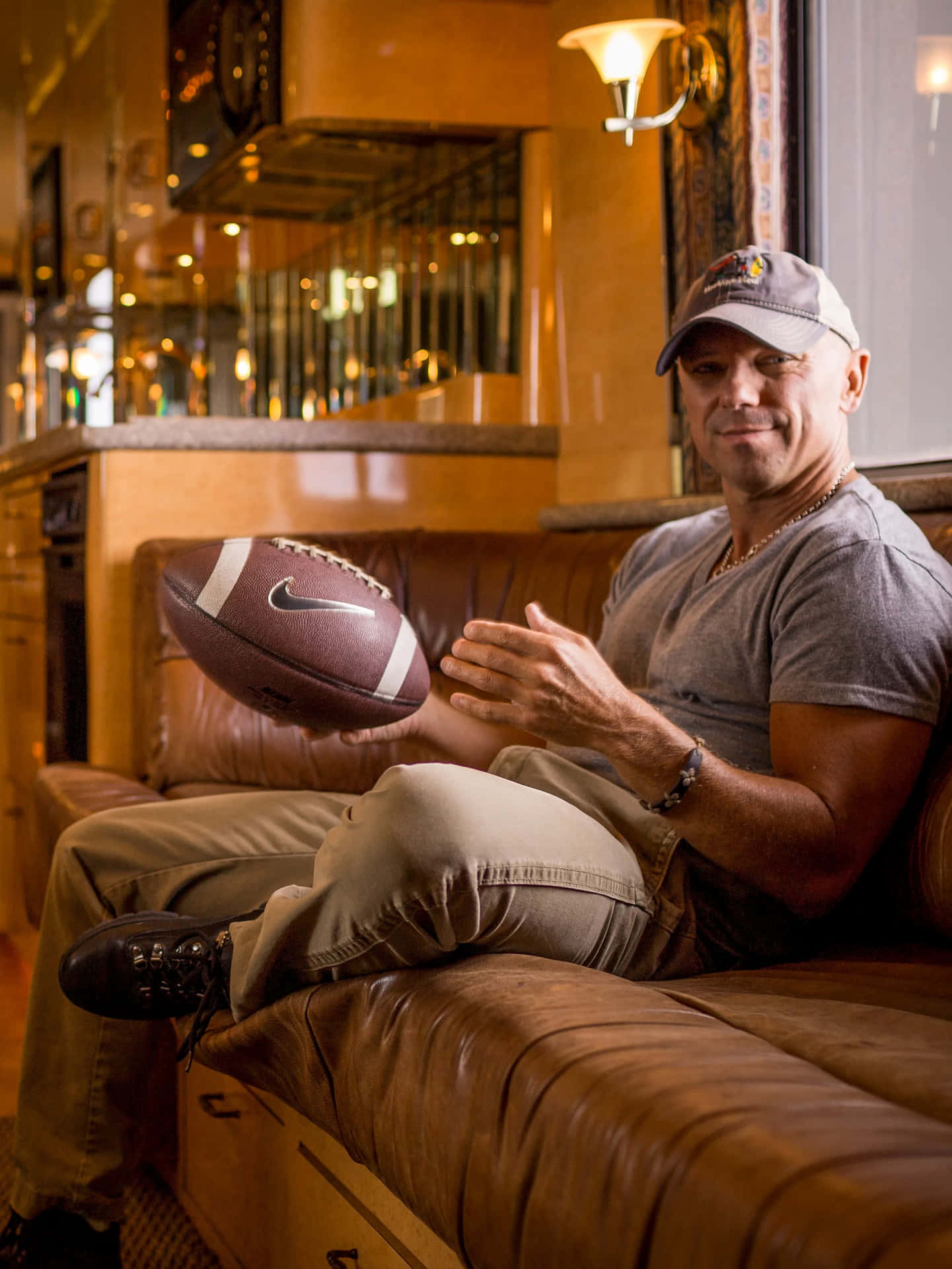 Kenny Chesney Holding Footballon Couch Wallpaper