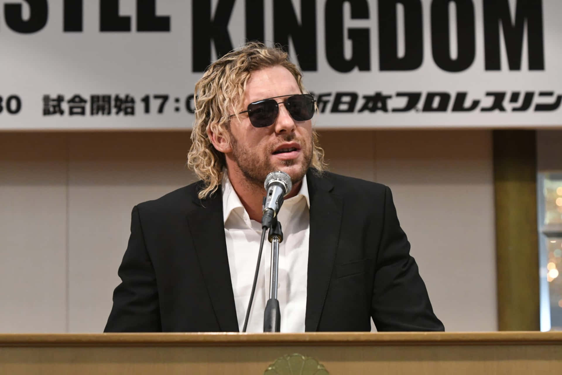 Kenny Omega Wearing A Suit And Sun Glasses Wallpaper