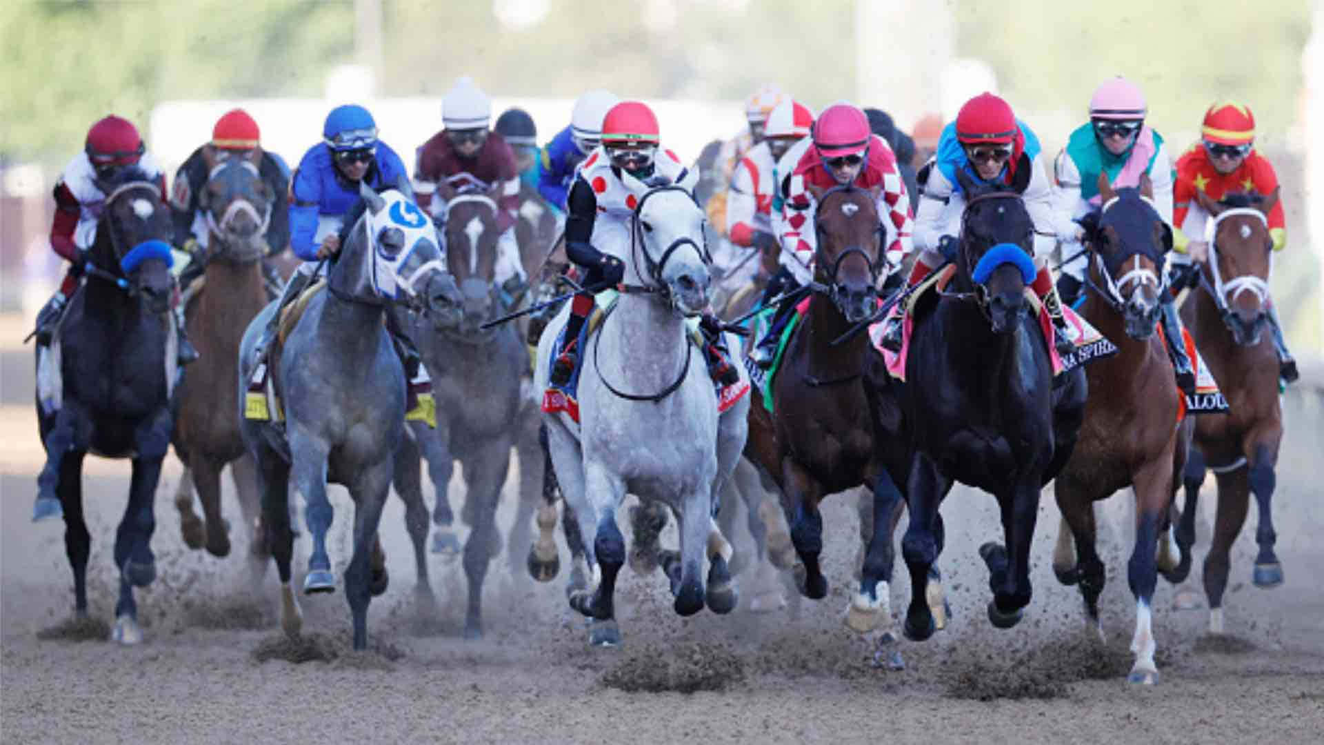 A Group Of Jockeys Are Racing On A Dirt Track