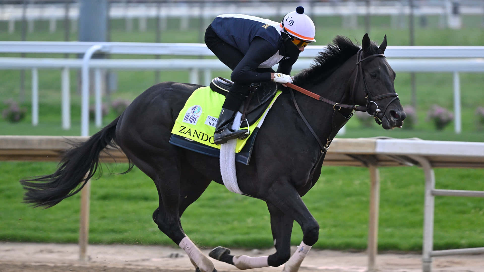 A Jockey Riding A Black Horse On A Track