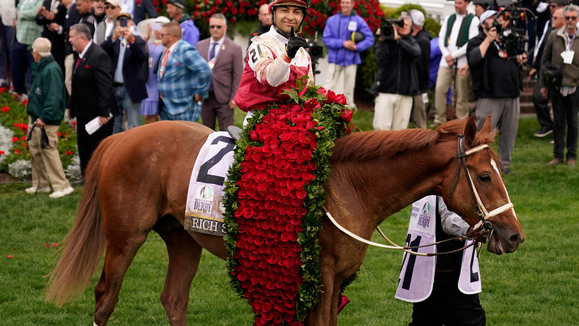 A Jockey Is Riding A Horse With Flowers On It