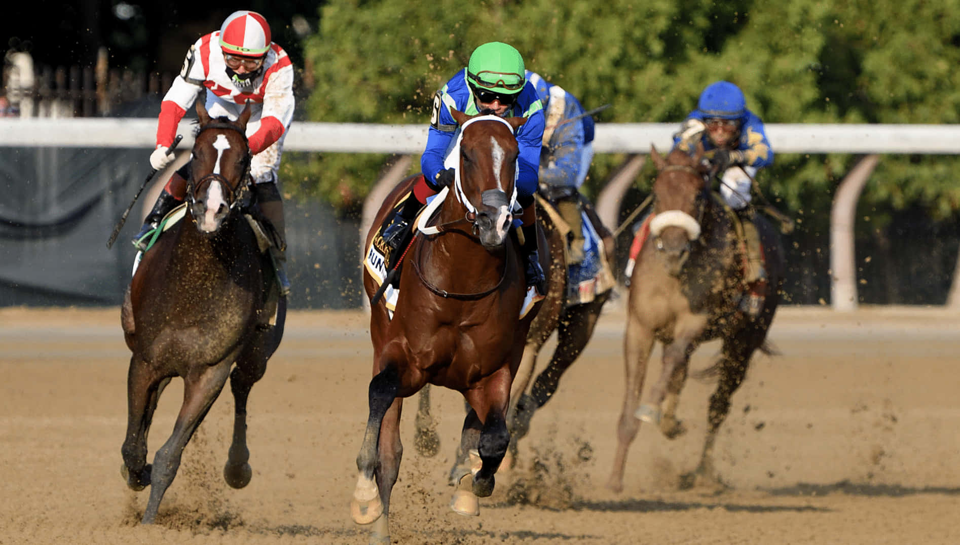 Three Jockeys Are Racing Horses On A Dirt Track