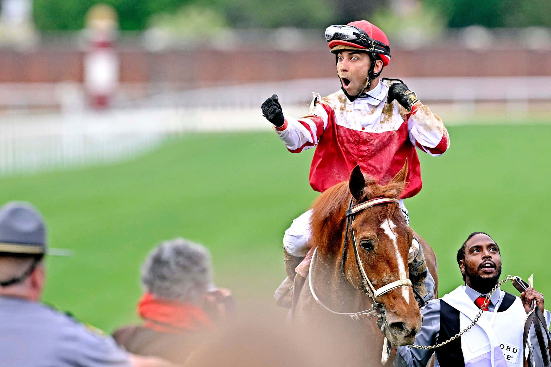 A Jockey Is Riding A Horse And Waving To The Crowd