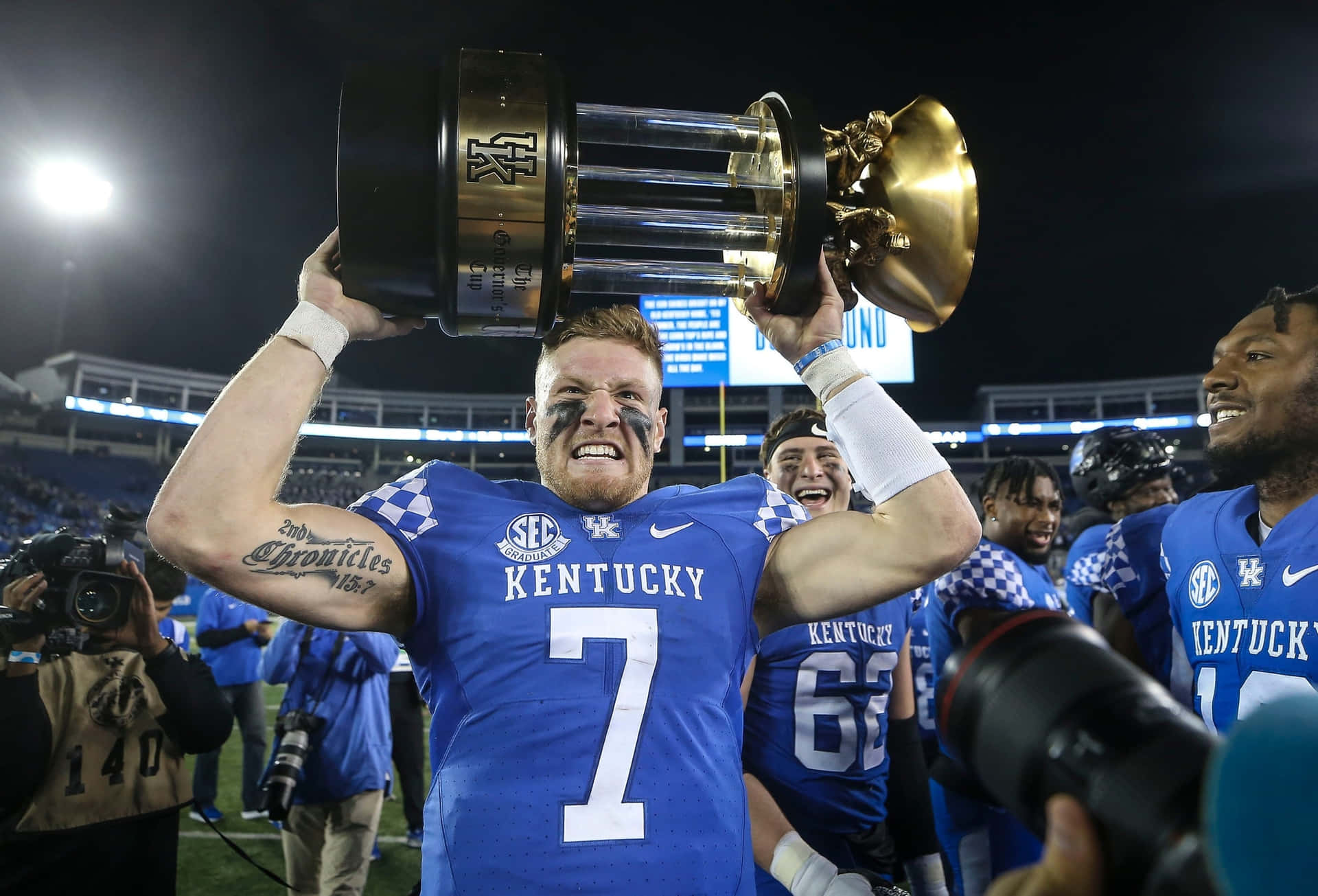 Kentucky Football Player Celebrates Victory With Trophy Wallpaper
